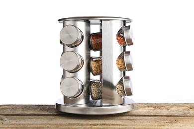 Photo of Many different aromatic spices in glass jars on wooden table against white background