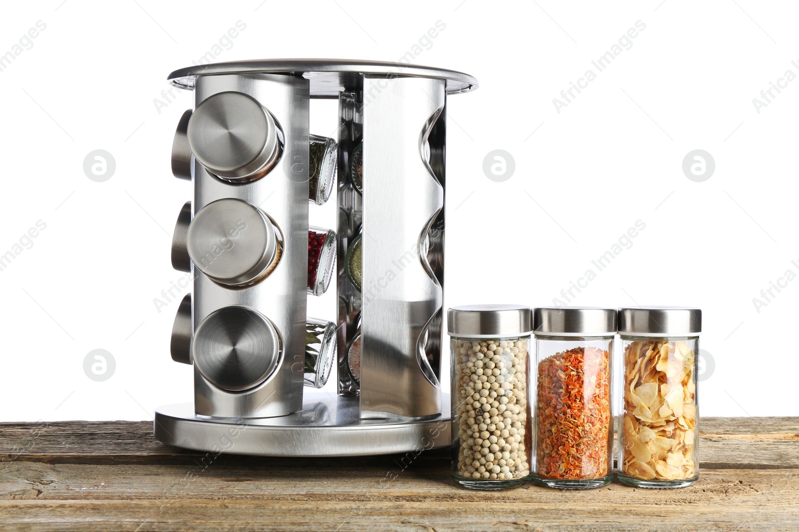 Photo of Many different aromatic spices in glass jars on wooden table against white background