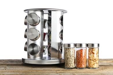 Photo of Many different aromatic spices in glass jars on wooden table against white background