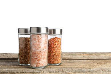 Photo of Many different aromatic spices in glass jars on wooden table against white background. Space for text
