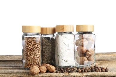 Photo of Many different spices and glass jars on wooden table against white background