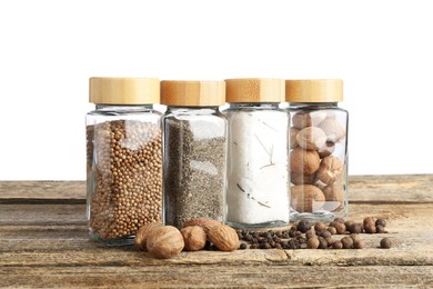 Photo of Many different spices and glass jars on wooden table against white background