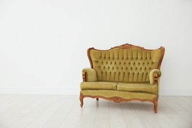 Photo of Stylish sofa near white wall indoors, space for text