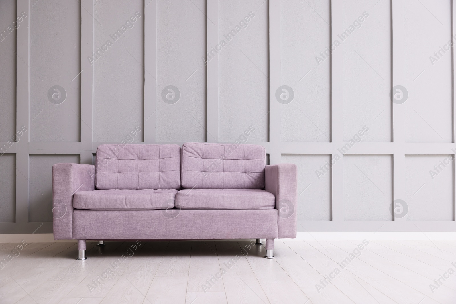 Photo of Comfortable violet sofa near gray wall in room