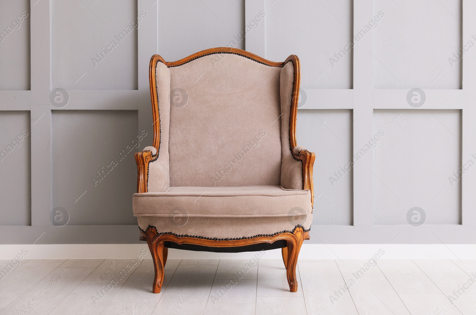 Stylish armchair and decor near gray wall in room Photo of Stylish armchair and decor near gray wall in room