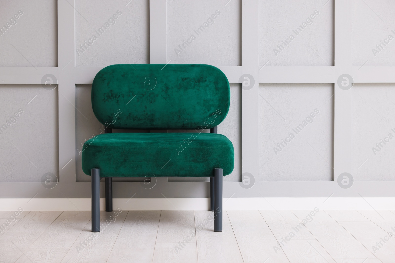 Stylish armchair near gray wall in room. Space for text Photo of Stylish armchair near gray wall in room. Space for text