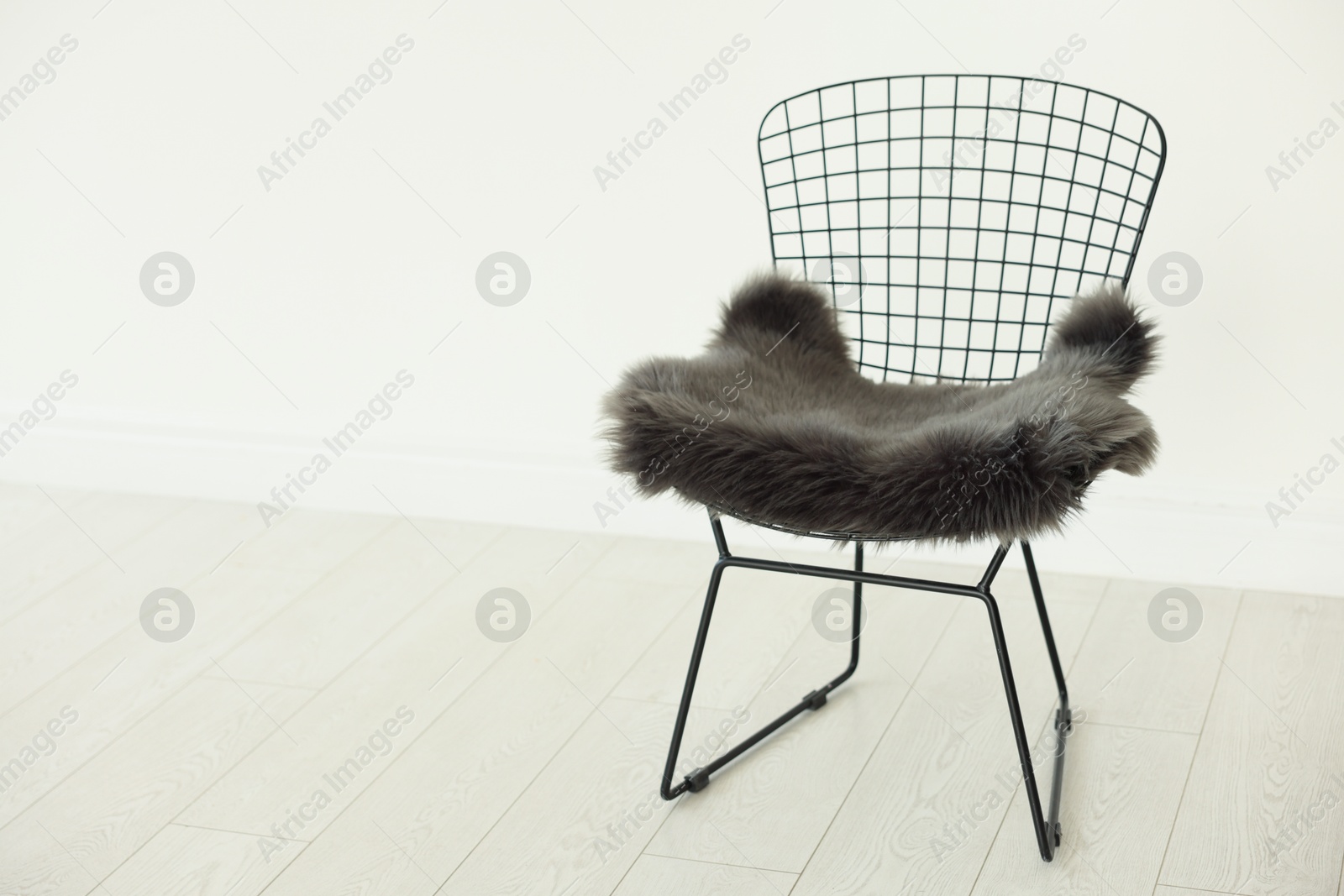 Photo of Stylish metal chair and fluffy blanket indoors, space for text