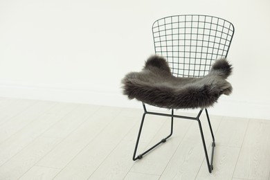 Photo of Stylish metal chair and fluffy blanket indoors, space for text