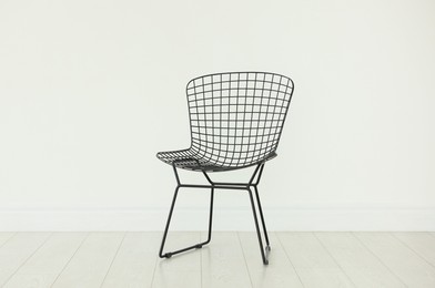 Photo of Stylish metal chair near white wall in room