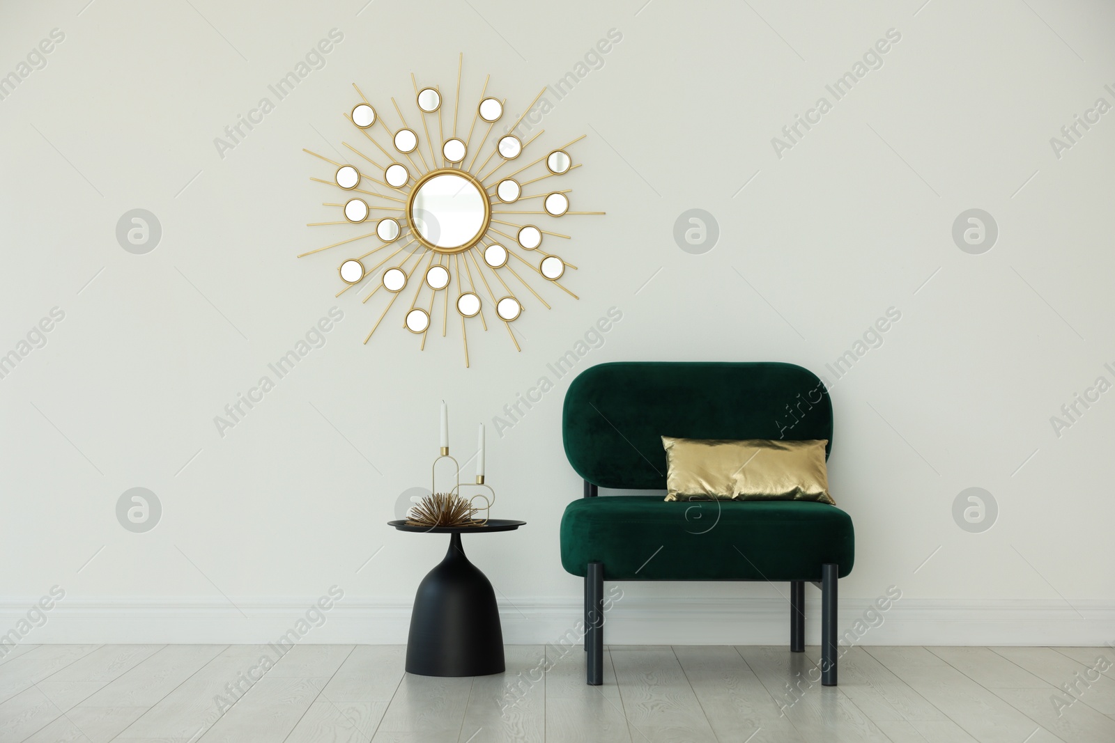 Stylish armchair with cushion and other decor near white wall in room. Interior design Photo of Stylish armchair with cushion and other decor near white wall in room. Interior design