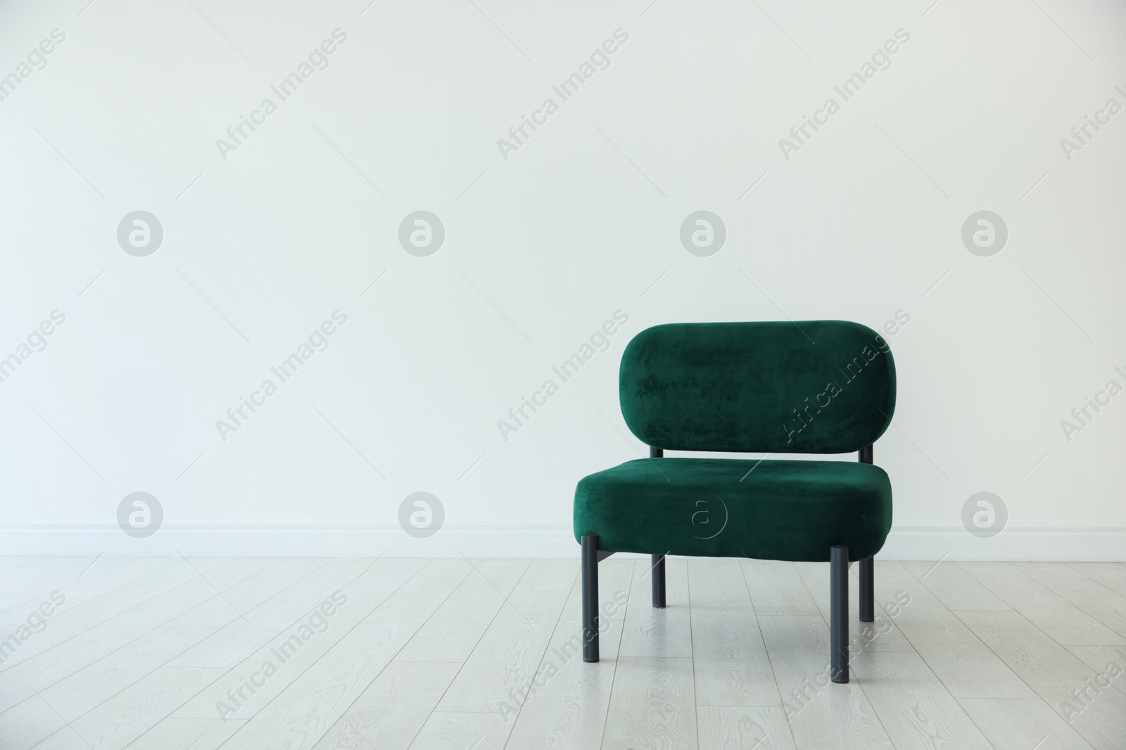 Photo of Stylish armchair near white wall in room, space for text