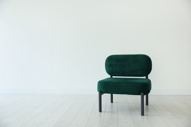 Photo of Stylish armchair near white wall in room, space for text