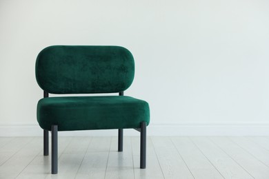 Photo of Stylish armchair near white wall in room, space for text