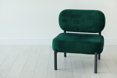 Photo of Stylish armchair near white wall in room, space for text