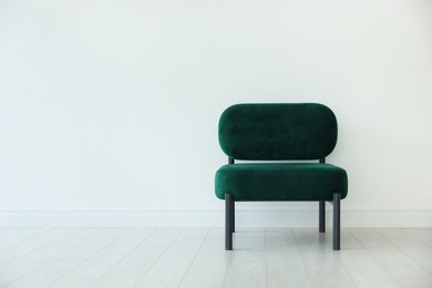 Photo of Stylish armchair near white wall in room, space for text