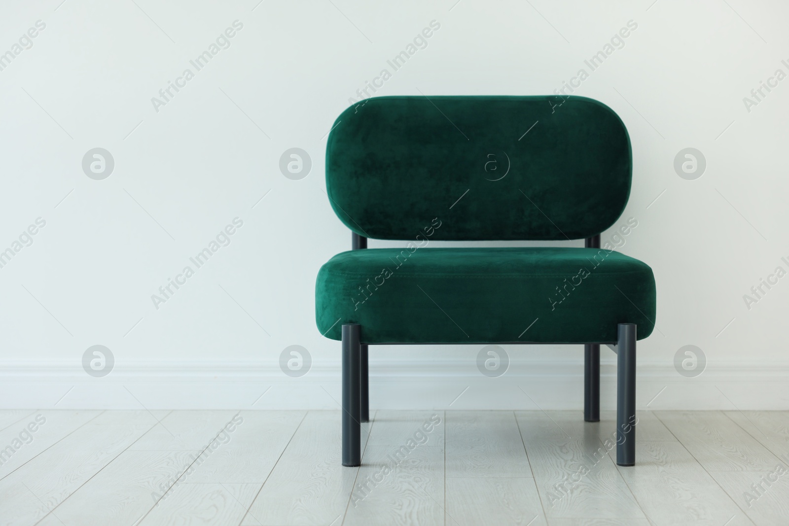 Photo of Stylish armchair near white wall in room, space for text