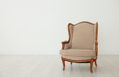 Photo of Stylish armchair near white wall indoors, space for text