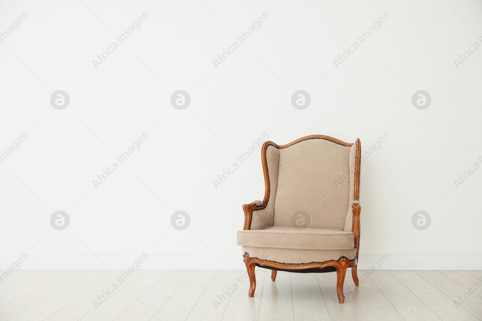 Photo of Stylish armchair near white wall indoors, space for text