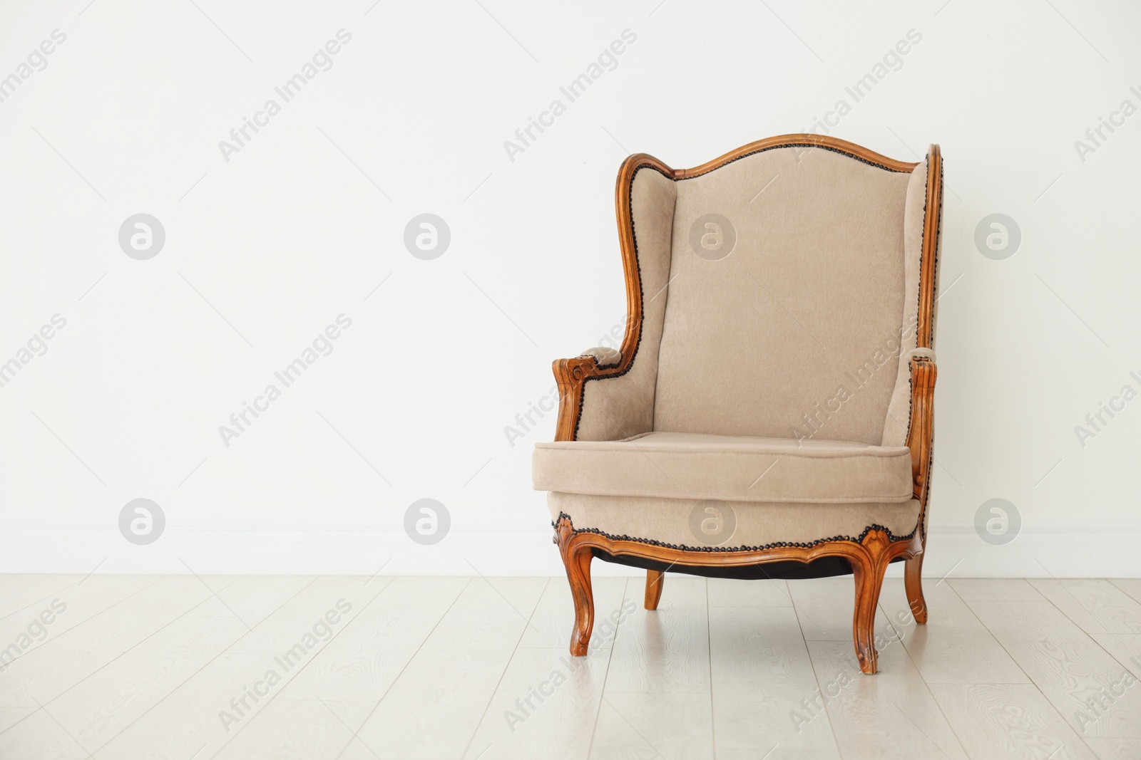 Photo of Stylish armchair near white wall indoors, space for text