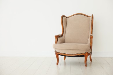 Photo of Stylish armchair near white wall indoors, space for text