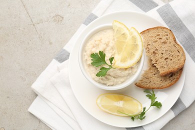 Photo of Tasty horseradish sauce with parsley and lemon slices served on light table, top view. Space for text