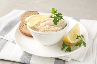 Photo of Tasty horseradish sauce with parsley and lemon slices served on light table, closeup