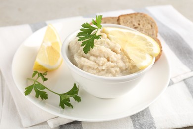 Photo of Tasty horseradish sauce with parsley and lemon slices served on light table, closeup