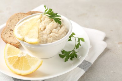 Photo of Tasty horseradish sauce with parsley and lemon slices served on light table, closeup