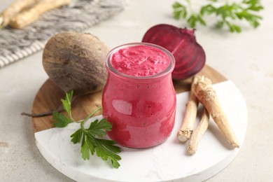 Photo of Tasty horseradish sauce with beetroot, parsley, roots and vegetables on light table, closeup