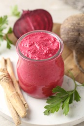Photo of Tasty horseradish sauce with beetroot, parsley, roots and vegetables on light table, closeup