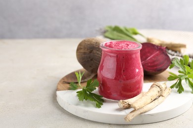 Photo of Tasty horseradish sauce with beetroot, parsley, roots and vegetables on light table, closeup. Space for text