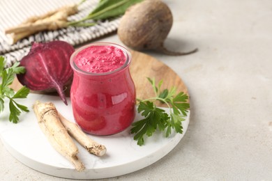 Photo of Tasty horseradish sauce with beetroot, parsley, roots and vegetables on light table, closeup. Space for text