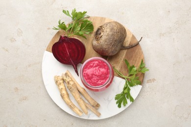 Photo of Tasty horseradish sauce with beetroot, parsley, roots and vegetables on light table, top view
