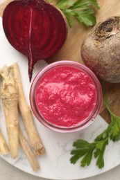 Photo of Tasty horseradish sauce with beetroot, parsley, roots and vegetables on light table, top view