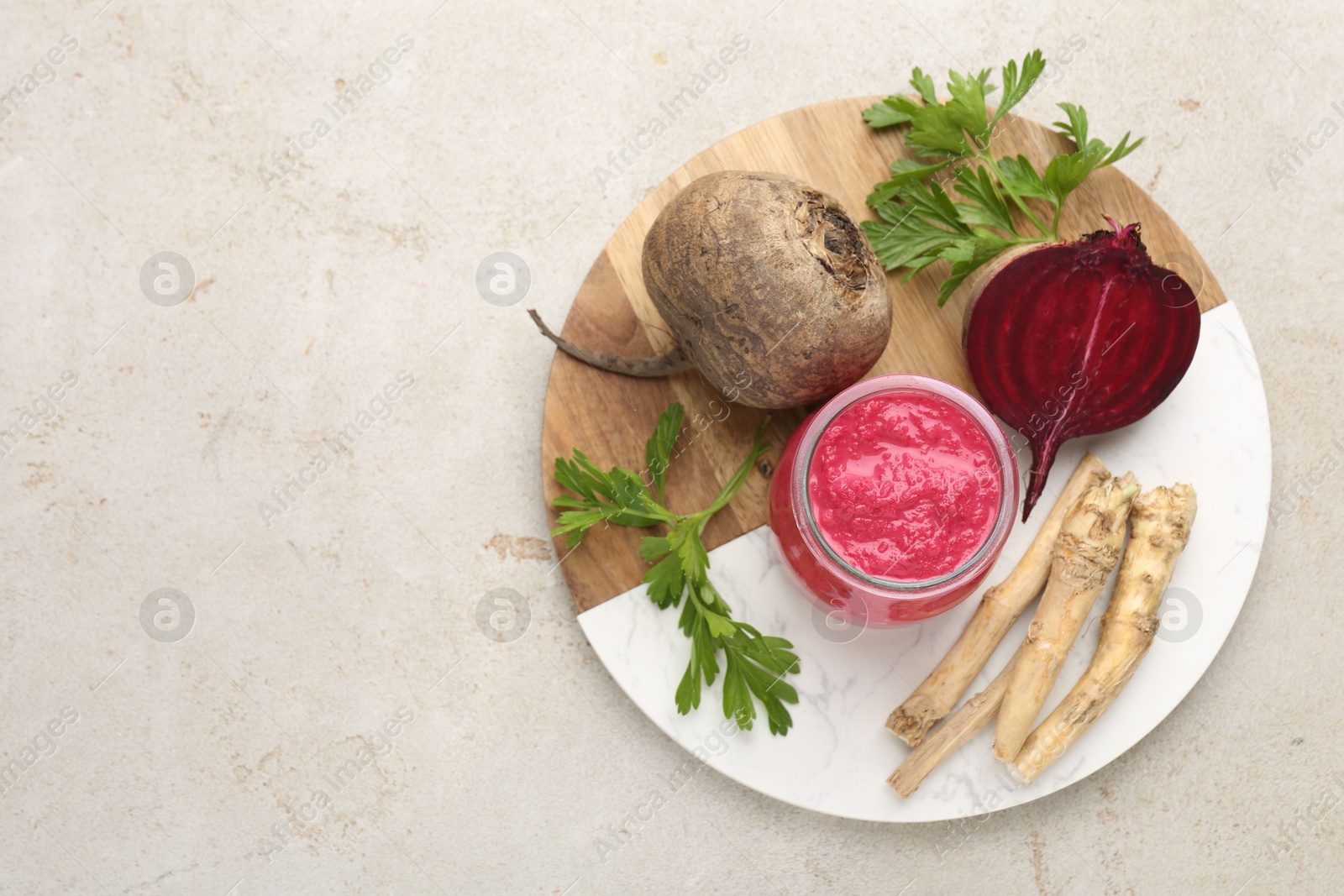 Photo of Tasty horseradish sauce with beetroot, parsley, roots and vegetables on light table, top view. Space for text