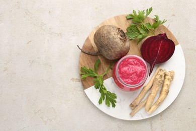Photo of Tasty horseradish sauce with beetroot, parsley, roots and vegetables on light table, top view. Space for text