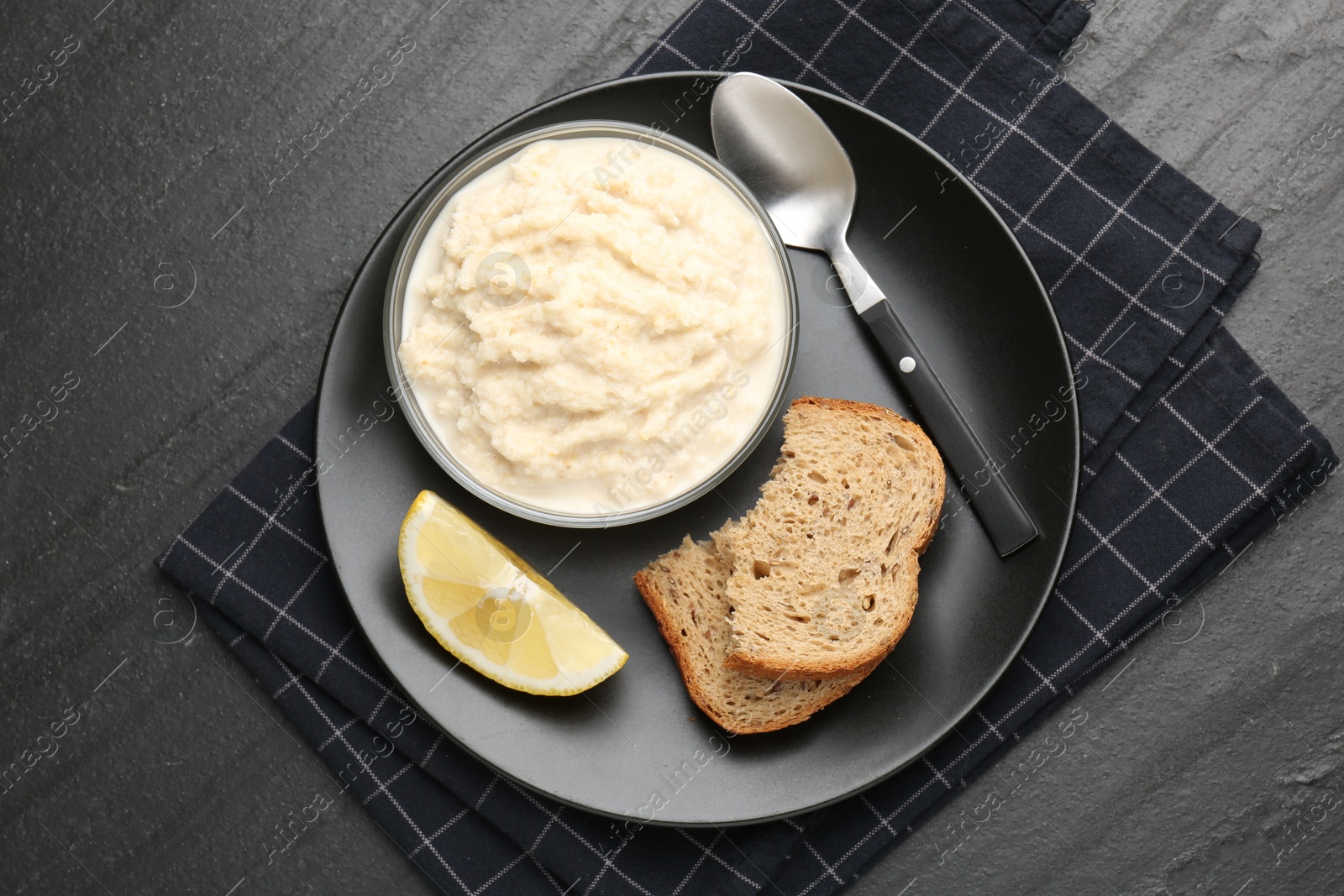 Photo of Tasty horseradish sauce served on black table, top view