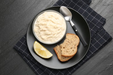 Photo of Tasty horseradish sauce served on black table, top view