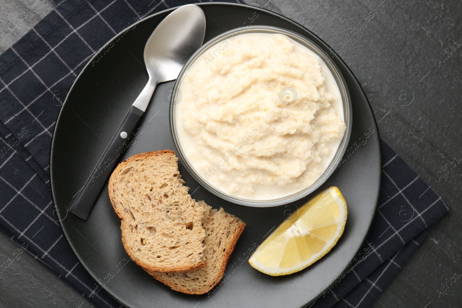 Photo of Tasty horseradish sauce served on black table, top view