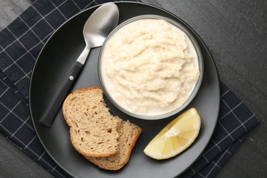 Photo of Tasty horseradish sauce served on black table, top view