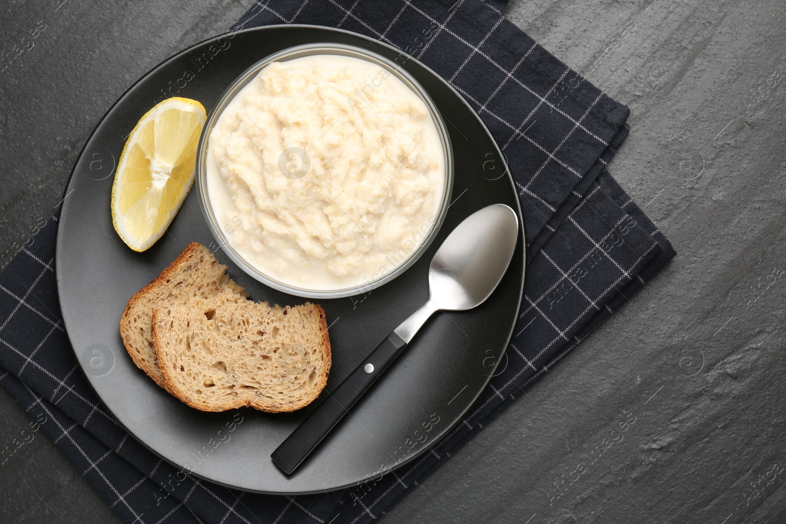 Photo of Tasty horseradish sauce served on black table, top view