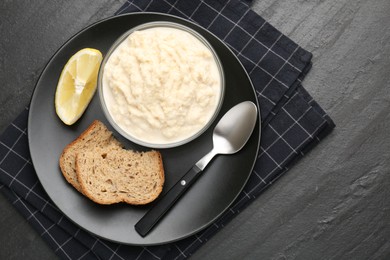 Photo of Tasty horseradish sauce served on black table, top view