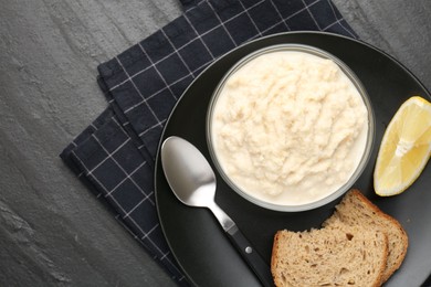 Photo of Tasty horseradish sauce served on black table, top view
