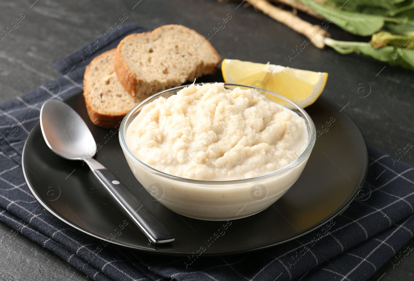 Photo of Tasty horseradish sauce served on black table, closeup