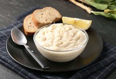 Photo of Tasty horseradish sauce served on black table, closeup