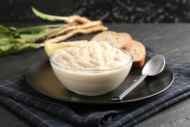Photo of Tasty horseradish sauce served on black table, closeup