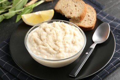 Photo of Tasty horseradish sauce served on black table, closeup