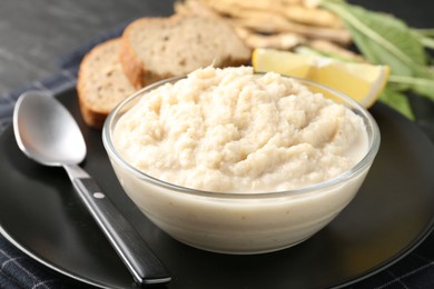 Photo of Tasty horseradish sauce served on black table, closeup