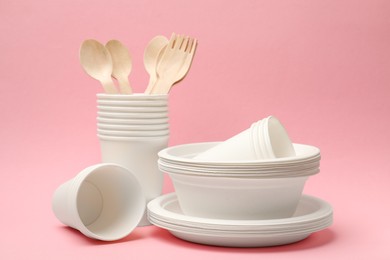 Photo of Set of disposable tableware on pink background