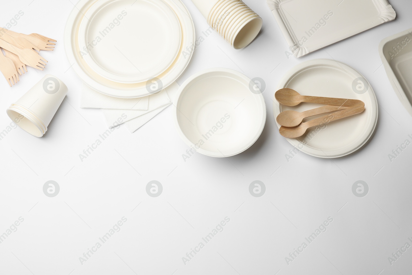 Photo of Set of disposable tableware and napkins on white background, flat lay